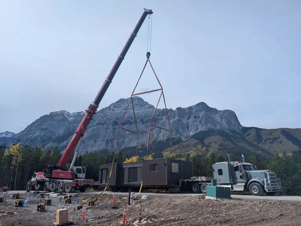 Bowline Logistics truck delivers a prefabricated modular unit to a mountain construction site where a crane prepares to lift the unit into place Bowline Logistics truck delivers a prefabricated modular unit to a mountain construction site where a crane prepares to lift the unit into place
