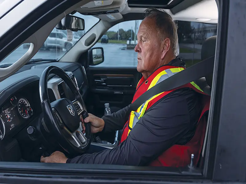 Pilot Truck Driver in safety vest in pick-up truck