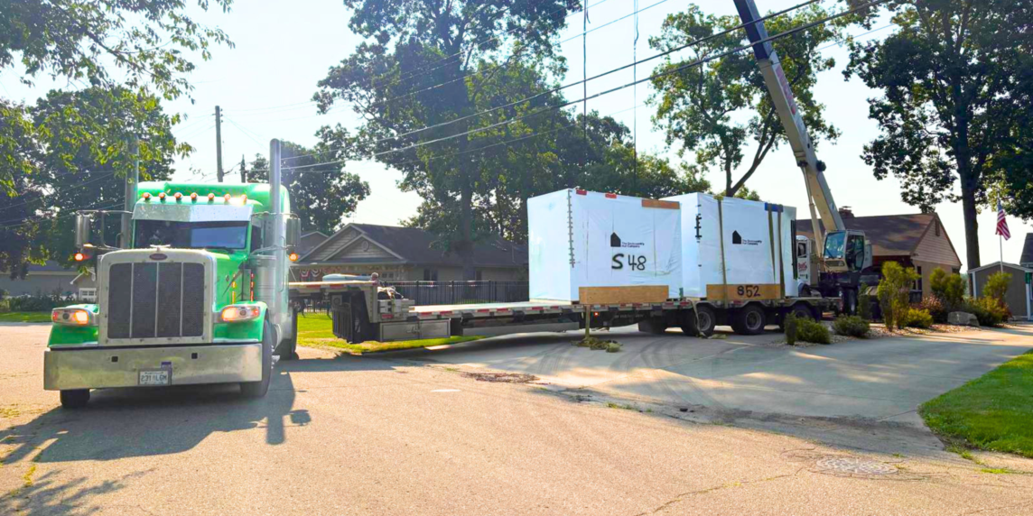 Bowline truck loading large equipment on a trailer in Western Canada.