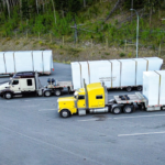 Heavy haul trucks transporting modular units on flatbed trailers during construction season in Western Canada